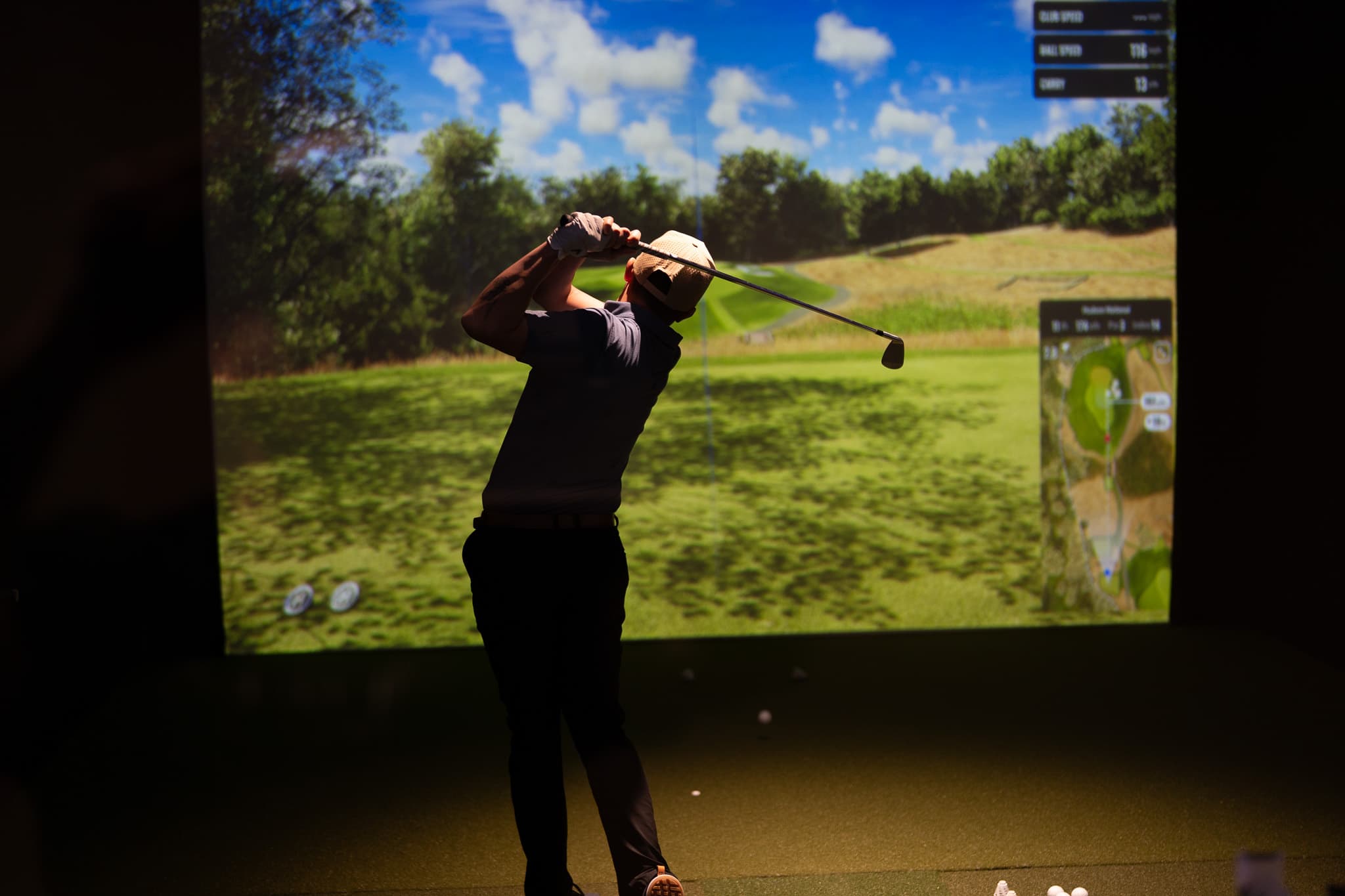 Member swinging in a private golf suite at the Sanctuary Brentwood